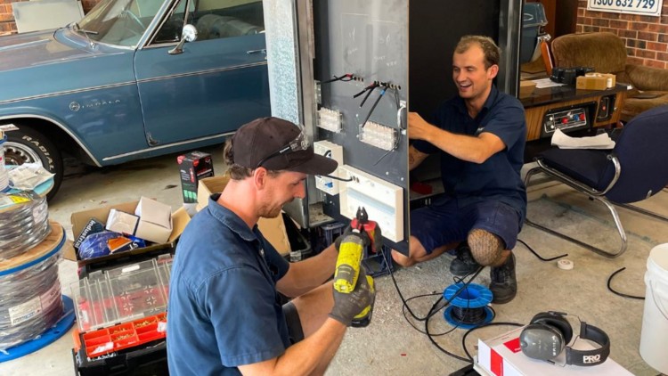 Electricians working on new switchboard installation